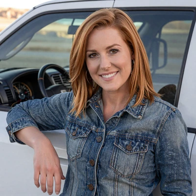 Danielle, 31, a woman with auburn hair in a denim jacket near a pickup truck in Casper Wyoming, trucker dating profile