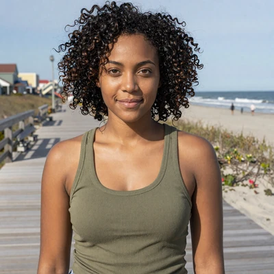 Tiffany, 28, a Black woman in a green top near a coastal Georgia boardwalk, trucker dating profile